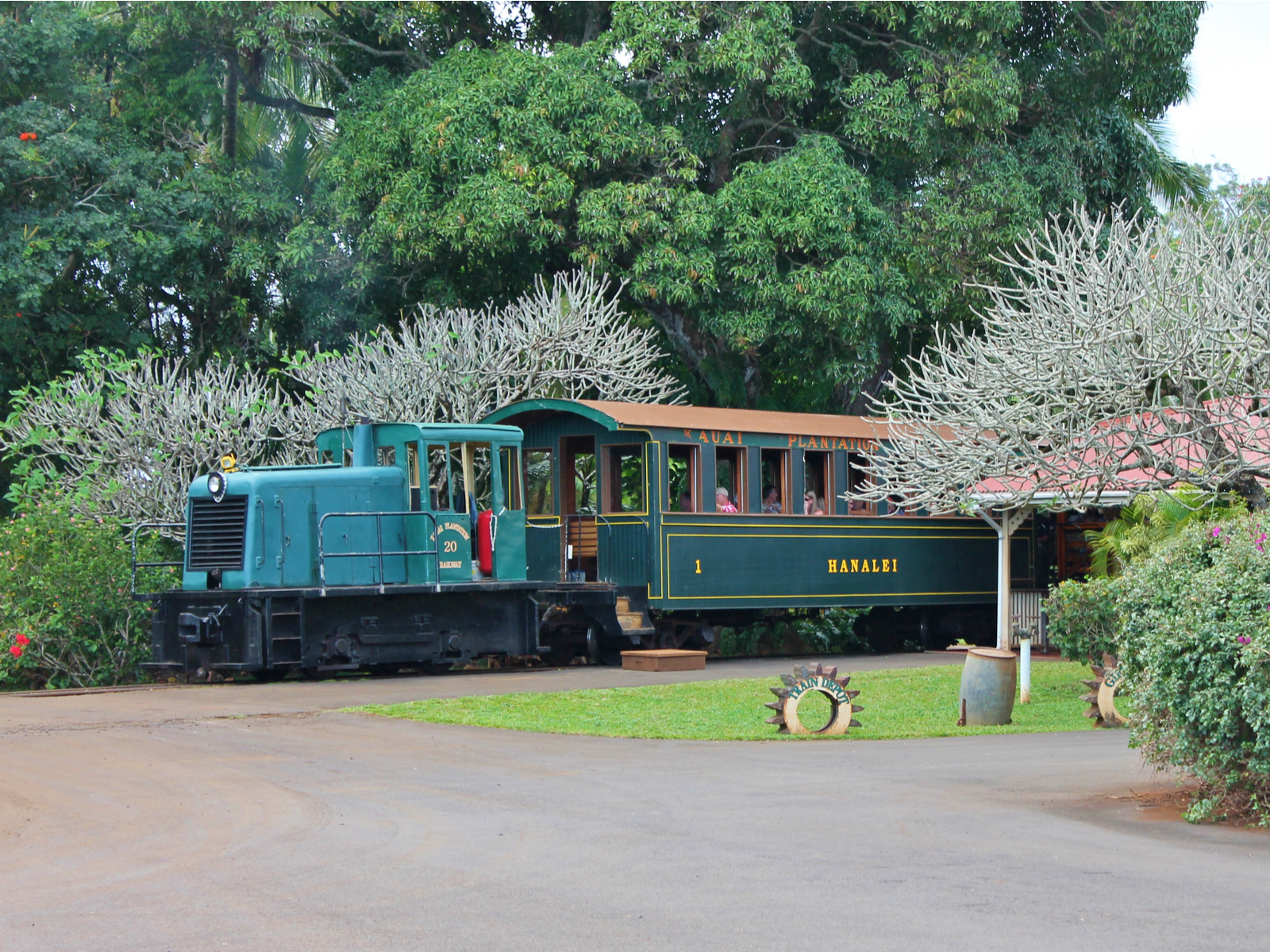 A classic passenger train stopping by at a waiting station, one of the best things to do in Kauai