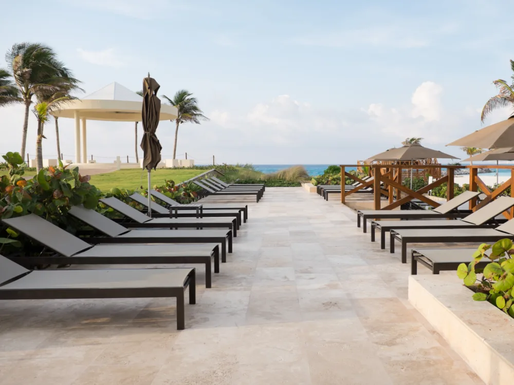 A series of relaxing beach loungers near an open sea at Hyatt Ziva, named as one of the best all-inclusive resorts in Cancun for families
