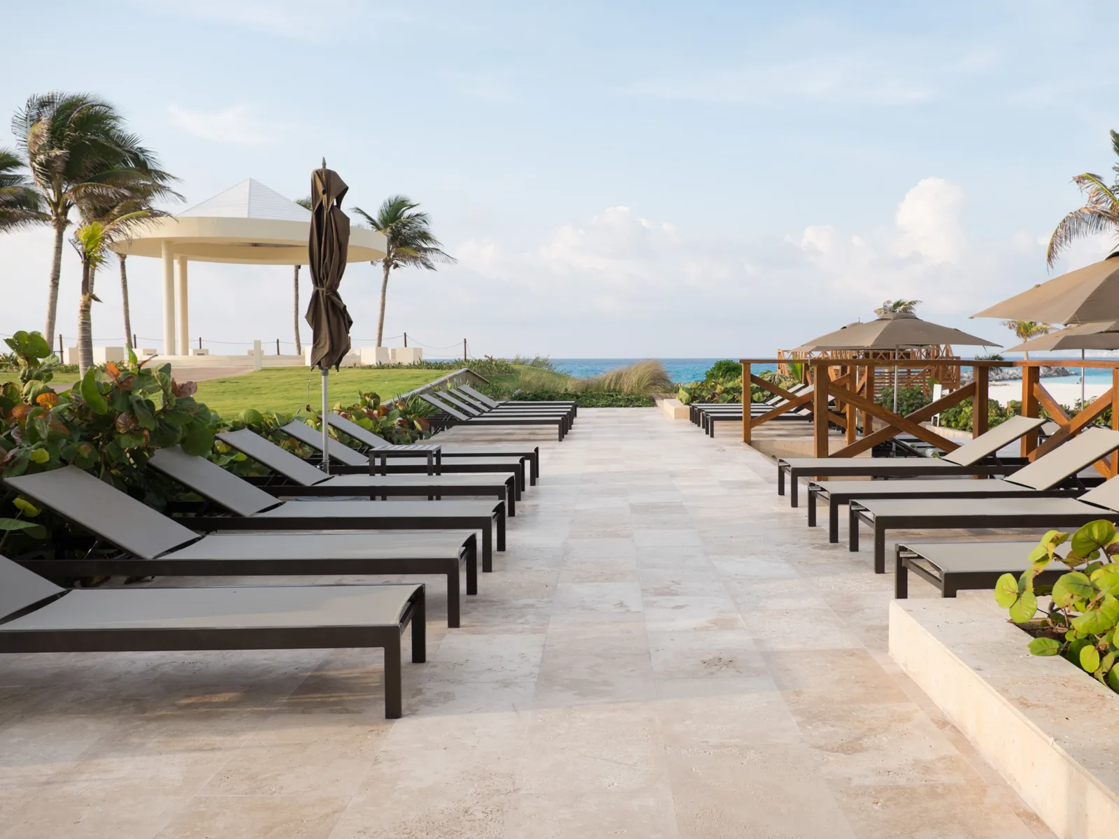 A series of relaxing beach loungers near an open sea at Hyatt Ziva, named as one of the best all-inclusive resorts in Cancun for families