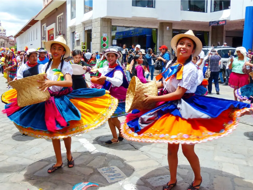 Two young woman spinning their colorful dresses pictured in a city street during the best time to visit Ecuador