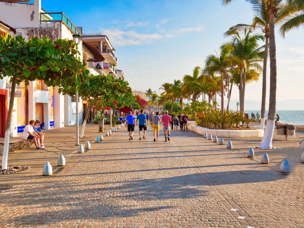 Group of people walking along a sea promenade in Malecon during the least busy time to visit Puerto Vallarta