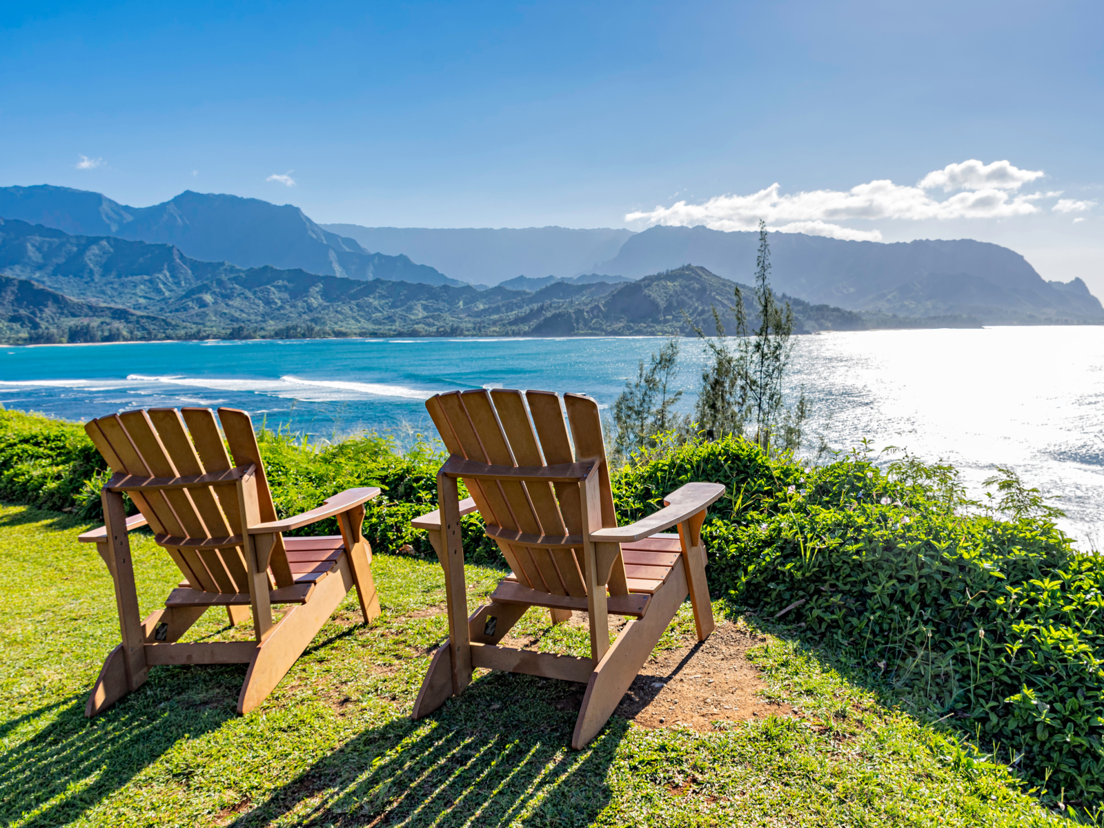 Adirondack chairs overlooking the ocean on a sunny day in one of the best hotels in Kauai