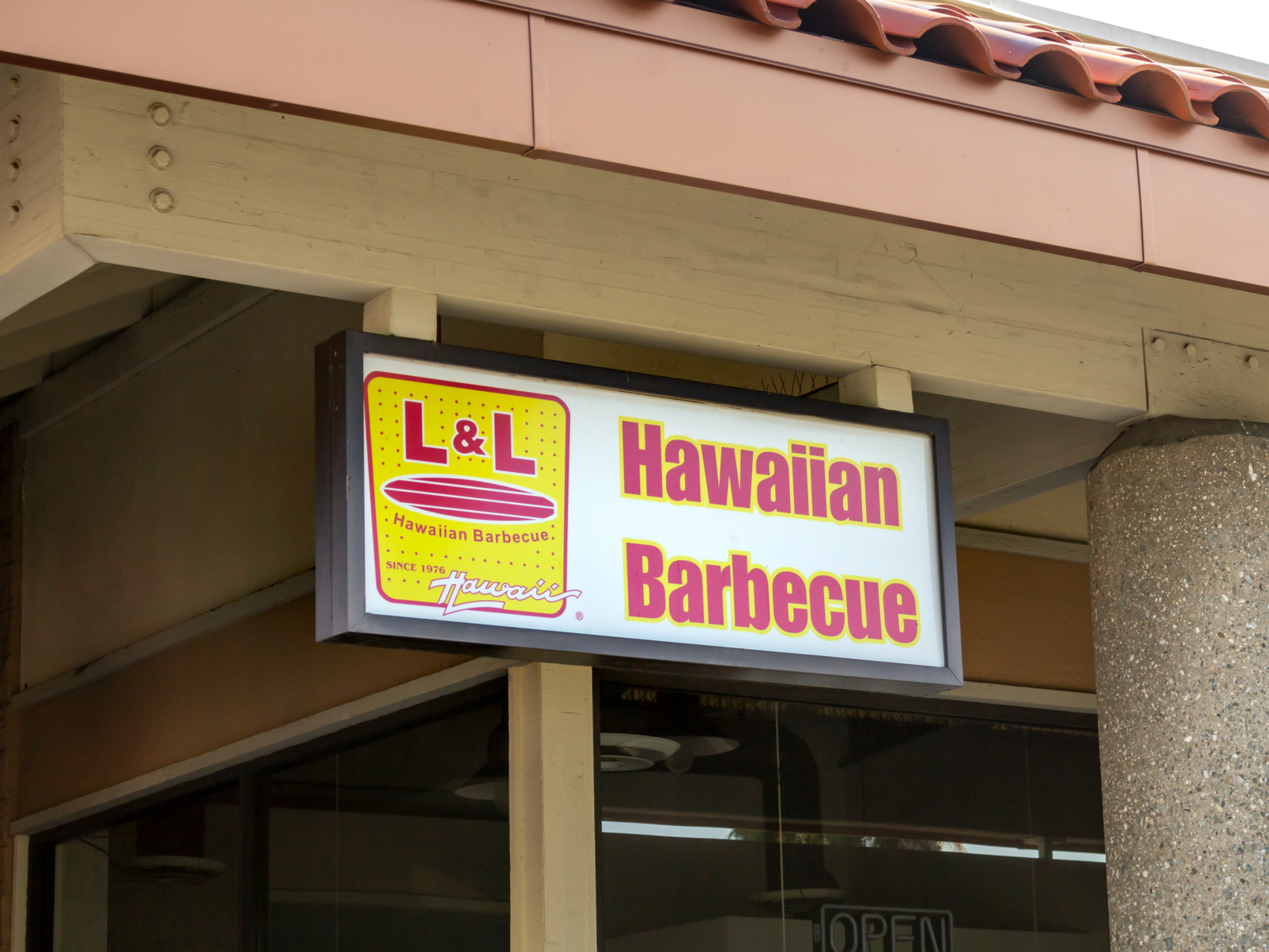 An L&L Hawaiian Barbecue sign is attached to the beam near a column at the restaurant, a piece on the best restaurants in Oahu