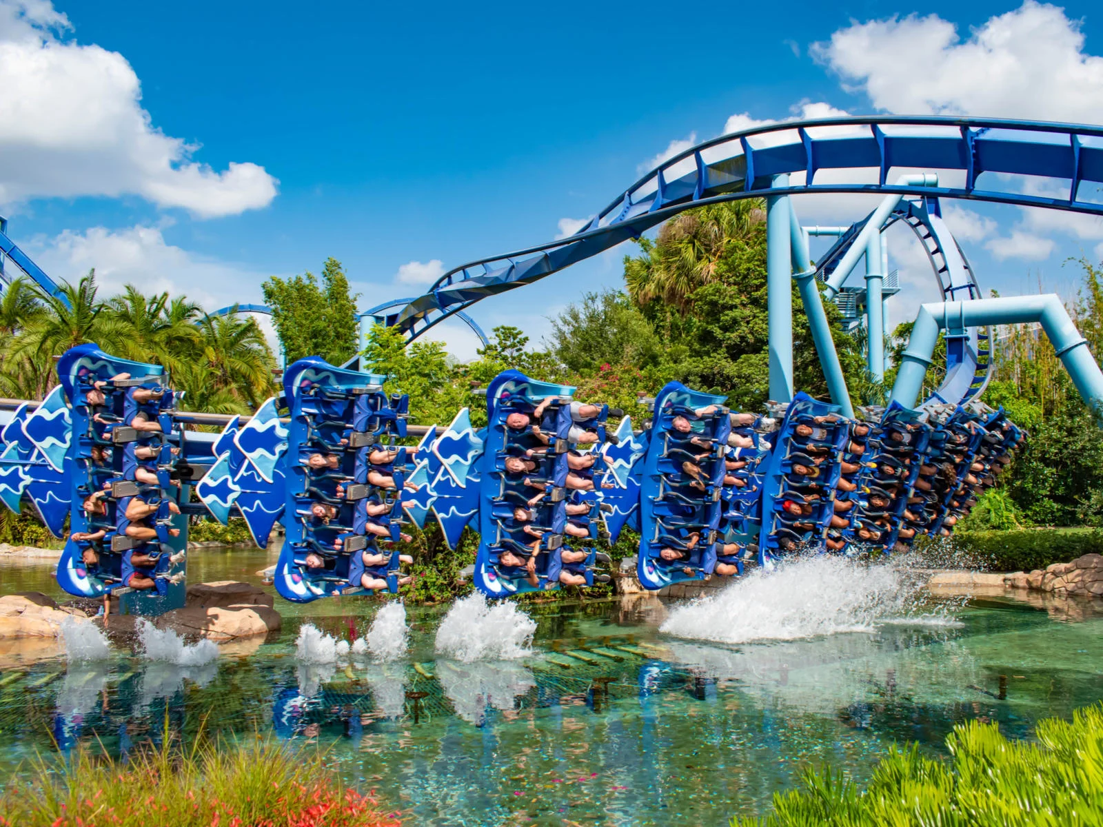 People are thrilled as the twisting Manta Ray roller coaster at SeaWorld in Orlando, Florida, one of the best roller coaster parks in the US, takes a sharp turn above a pond