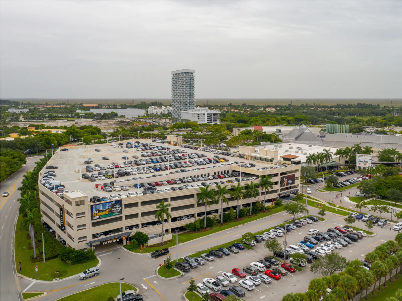 Aerial view on one of the biggest outlet malls in the US and one of the best things to do in Fort Lauderdale, Sawgrass Mills where numerous cars are parked at the roof deck and parking space