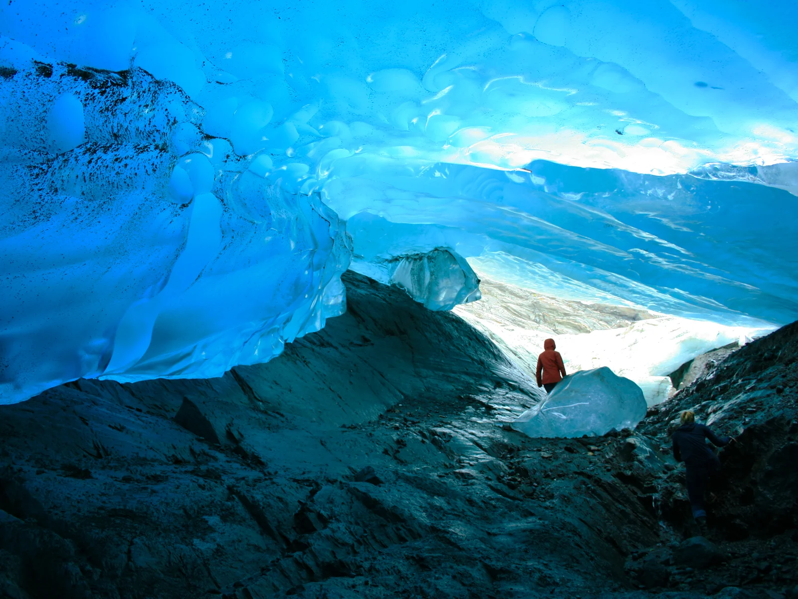 A woman exploring the chilly Mendenhall Ice Caves in Alaska, one of the most beautiful places in the US