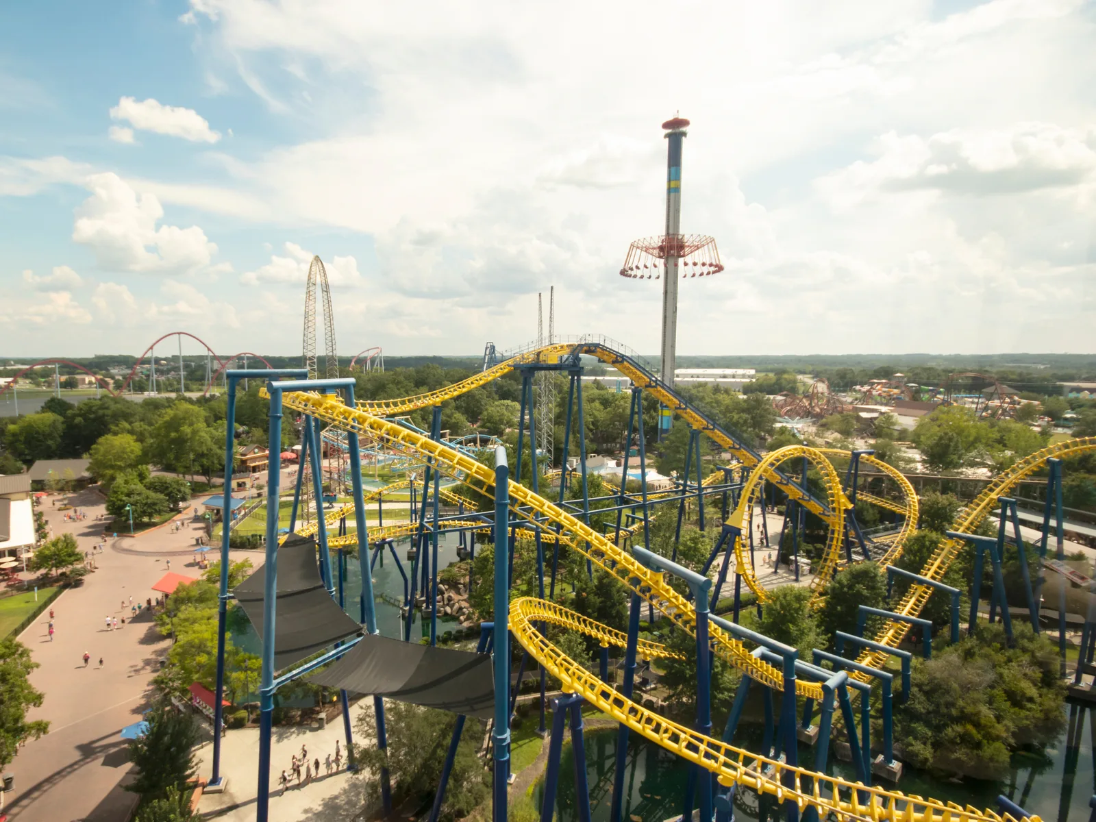 a long roller coaster with yellow tracks and a tall drop tower visible from a stunning aerial view of carowinds, one of the best things to do in charlotte, nc