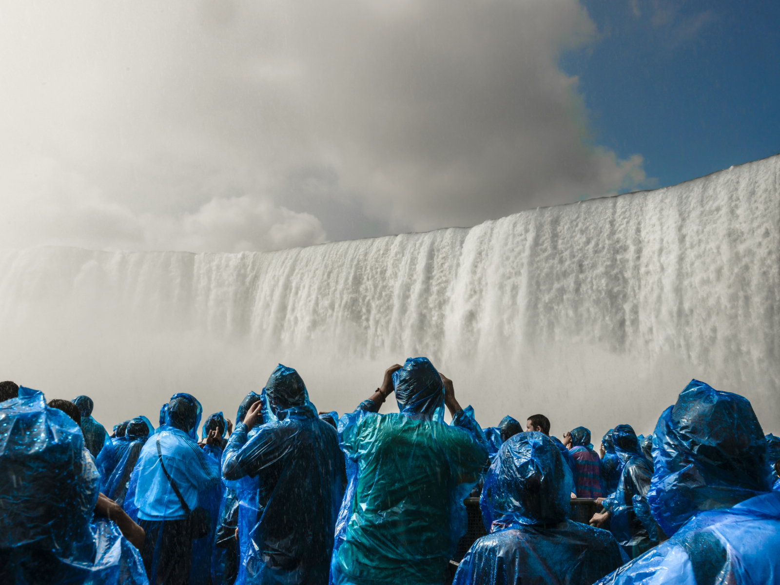 People going under the water in ponchos during the best time to visit Niagara Falls
