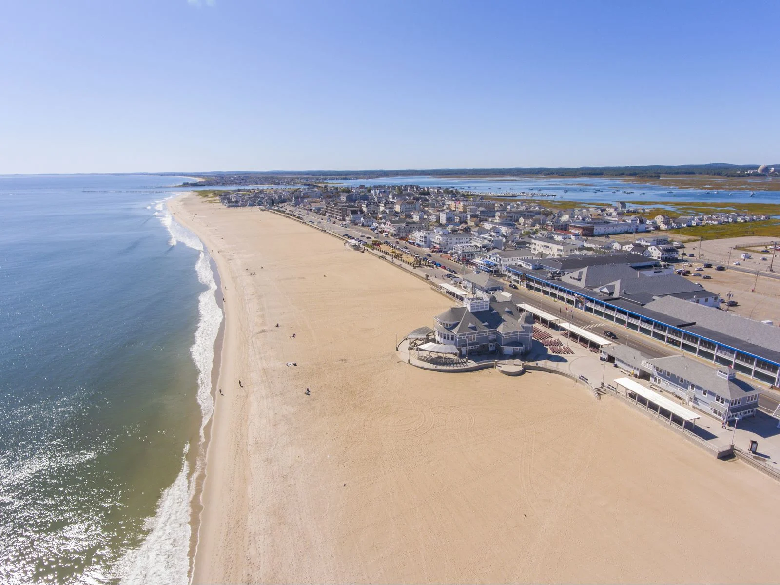 Clear wide coast at Hampton Beach in New Hampshire, titled as one of the best beaches on the East Coast, with a highway a little far offshore