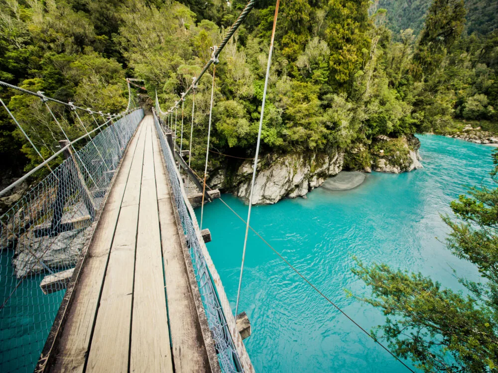 Hokitika Gorge bridge above teal water during the least expensive time to visit New Zealand
