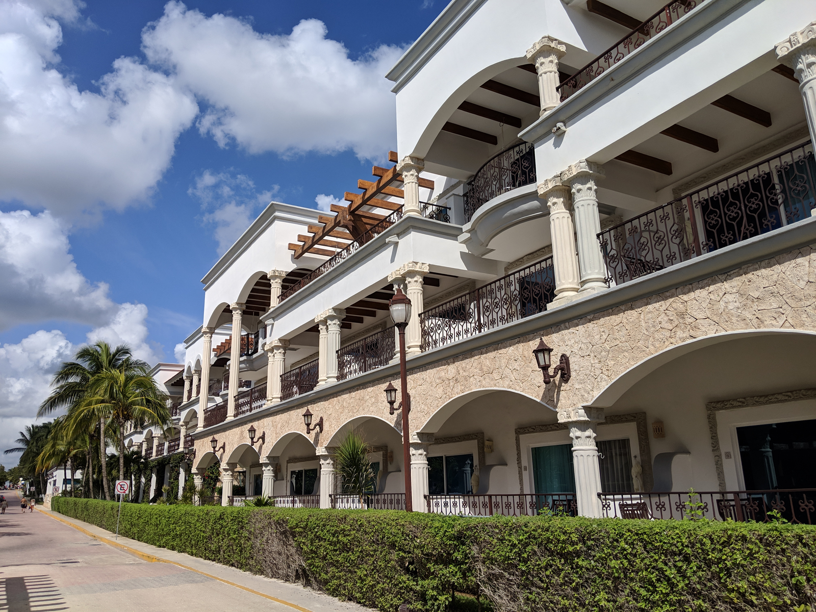 Exterior view on Hilton Playa del Carmen, one of the best all-inclusive resorts in Mexico, with its decorative columns and trimmed sidewalk plants