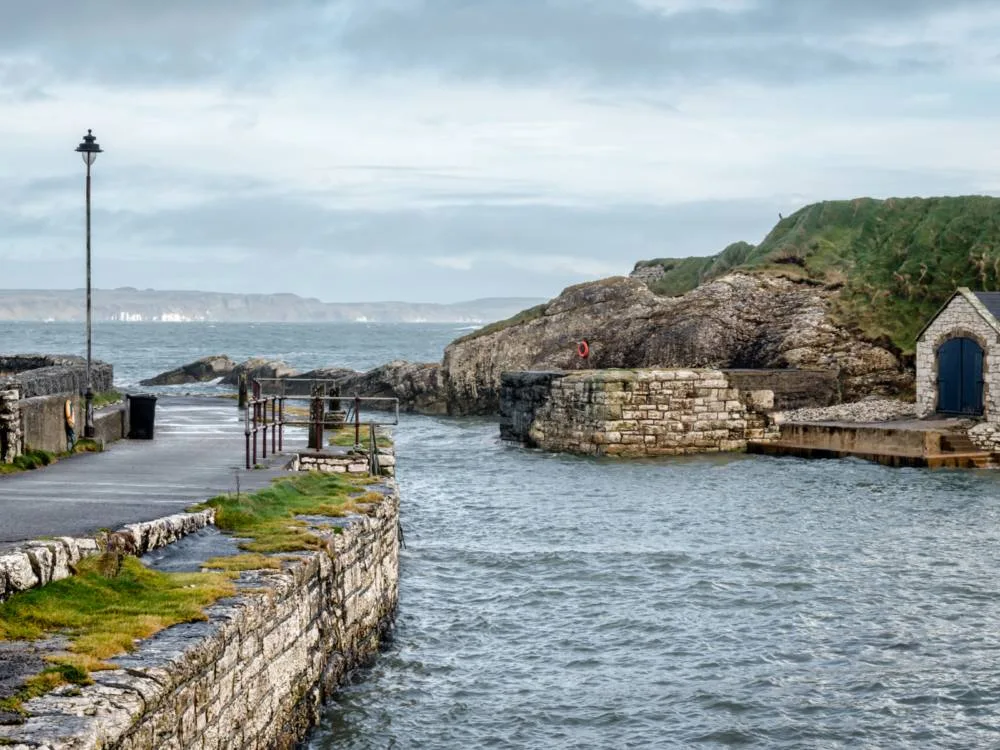 Wavy sea at one of the Game of Thrones filming locations you can visit, Ballintoy Harbour in Northern Ireland on an overcast day