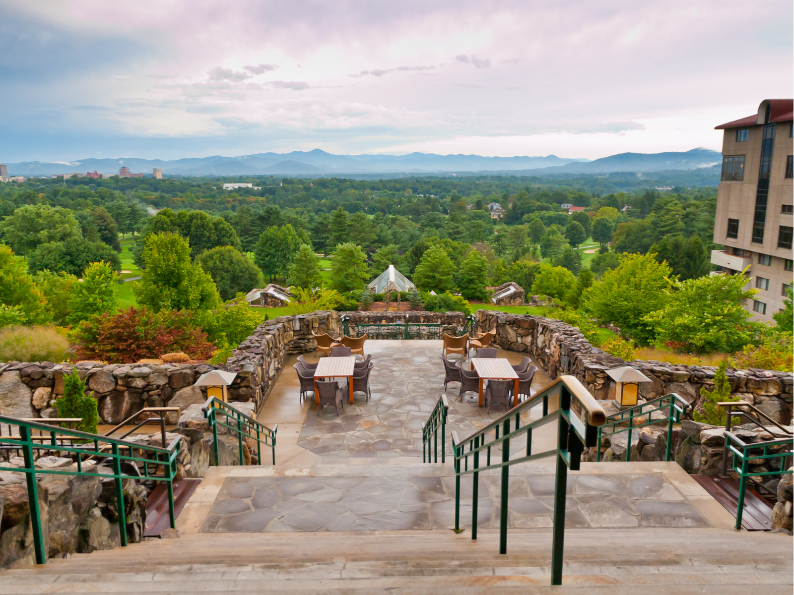 Empty chairs and tables with an overlooking view of Omni Grove Park's skyline, one of the best things to do in Asheville, NC