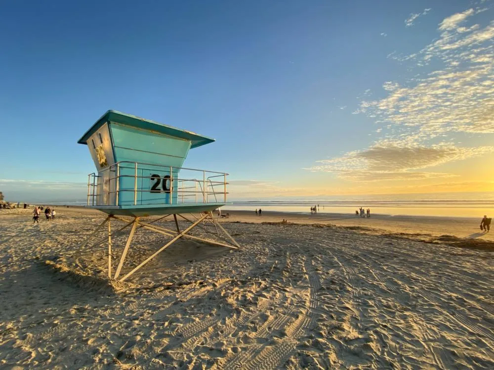 A lifeguard tower at the vast shore on Coronado Beach in California, one of the best beaches in the US, people enjoying the sweet sunset