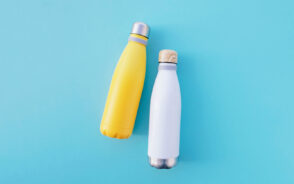 Stylish reusable water bottles that are insulated in blue and yellow on a blue background