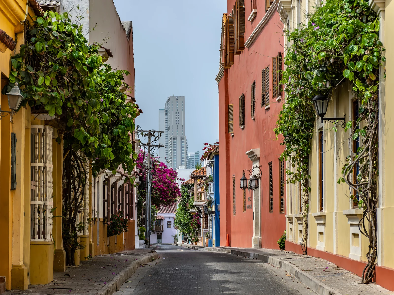 Colonial neighborhood with the downtown skyline in the background and yellow and pink walls during the least busy time to visit San Diego