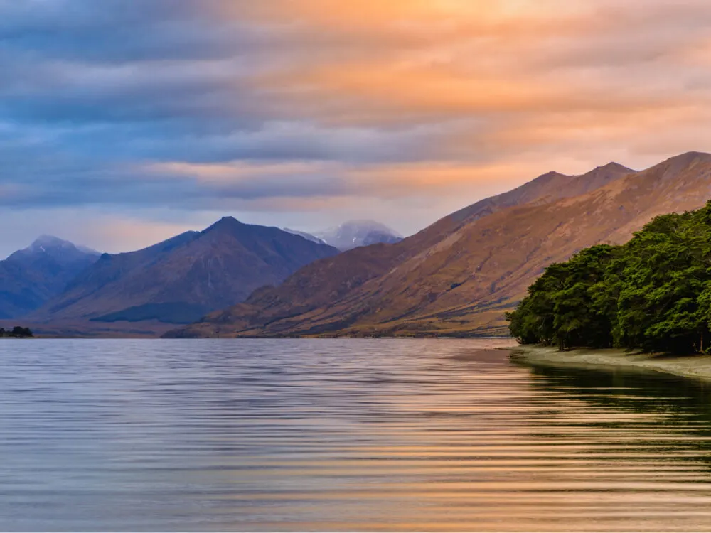 One of Lord of the Rings filming locations, Mavora Lake which is surrounded by tall mountains at sunset