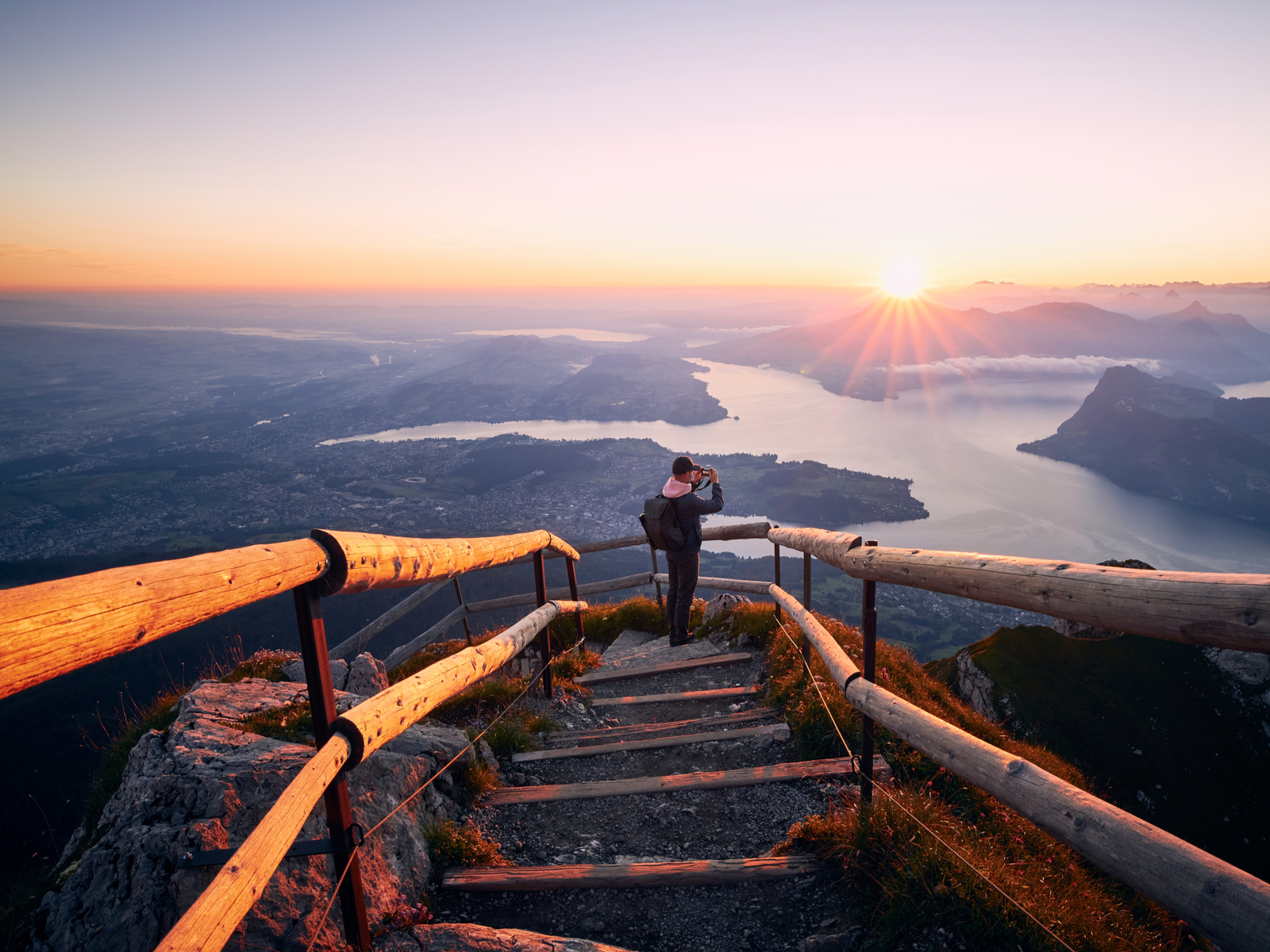 Man photographing the sunrise from Mount Pilatus during the best time to visit Switzerland