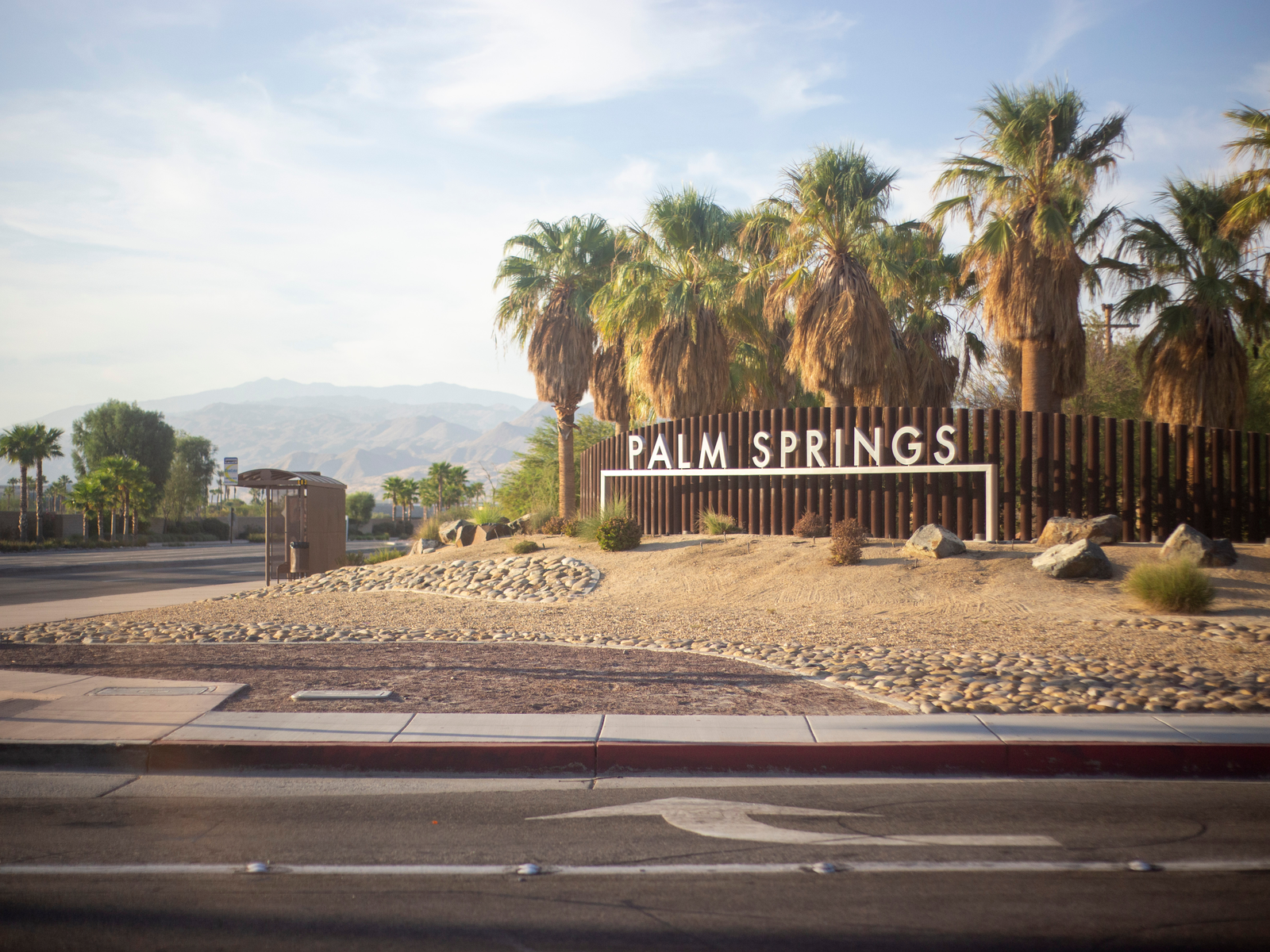 A bus stop near the huge signage of Palm Springs with palm trees in backdrop, one of the best things to do in Palm Springs