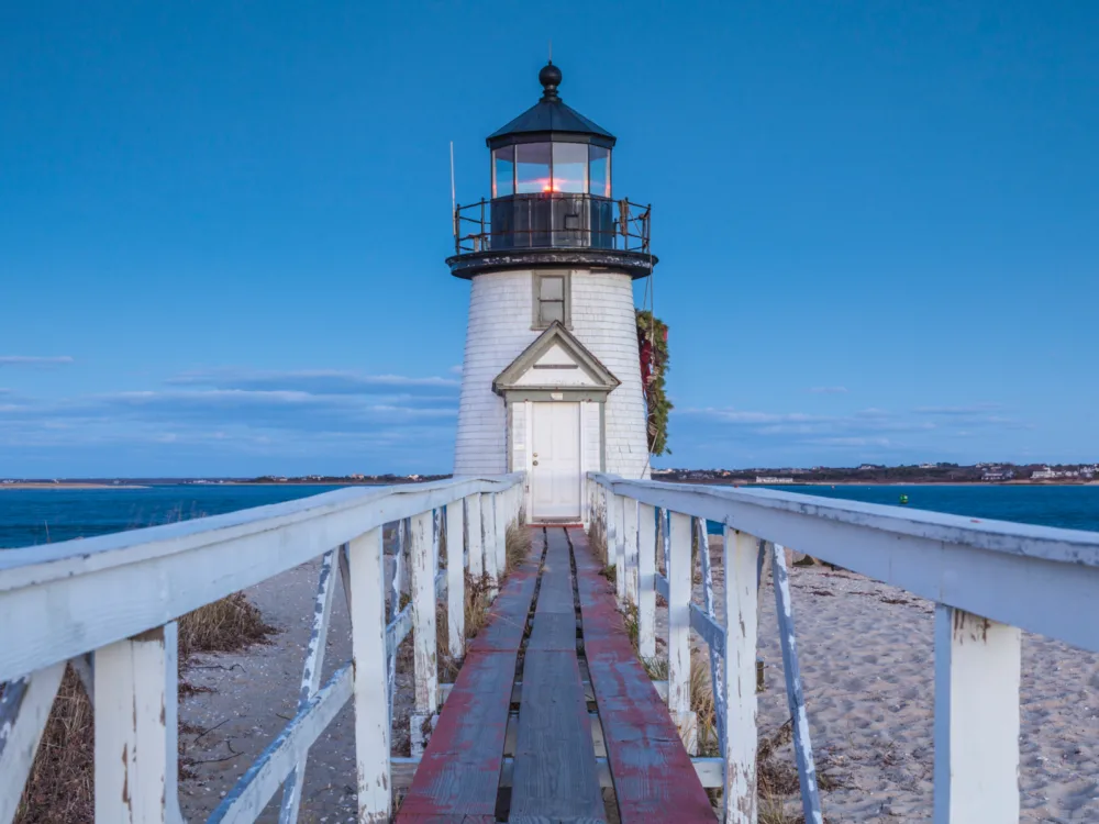 A boardwalk leading to the iconic Brant Point Lighthouse in Nantucket Island, Massachusetts, one of the most beautiful cities in the US
