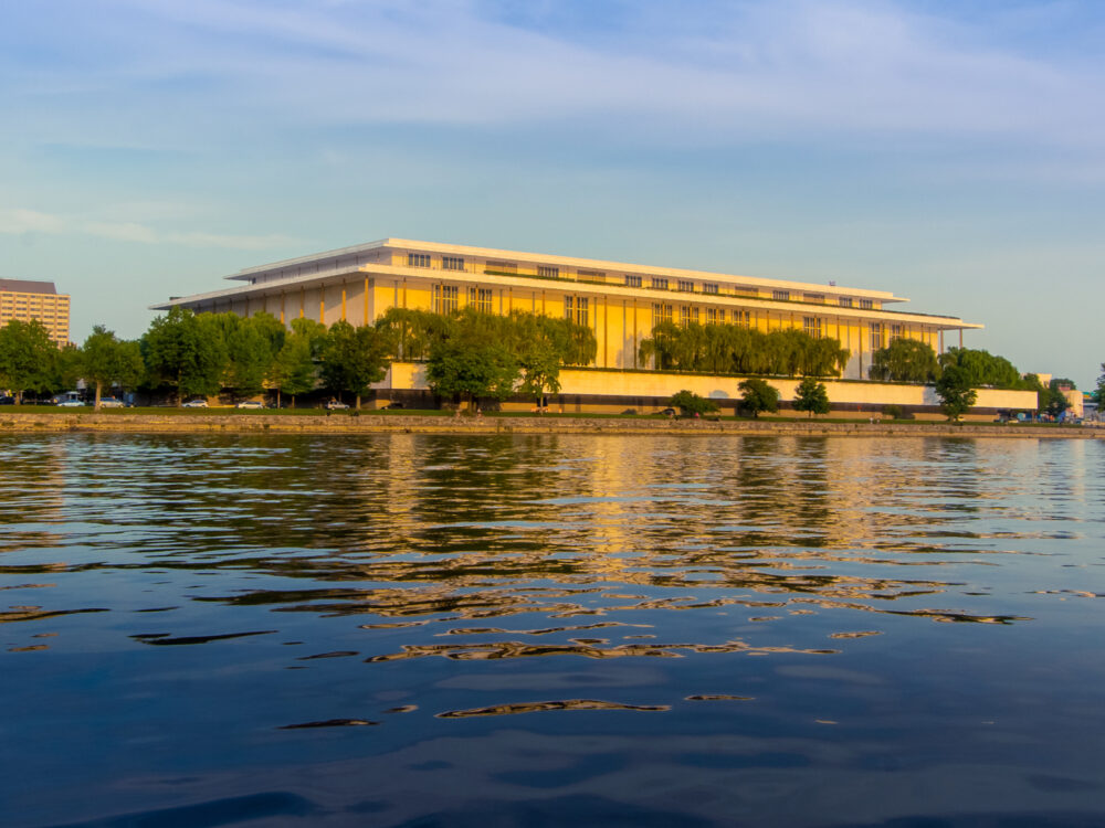 Beautifully illuminated John F Kennedy Center for the Performing Arts reflected from Potomac River is one of the best things to do in Washington, D.C.