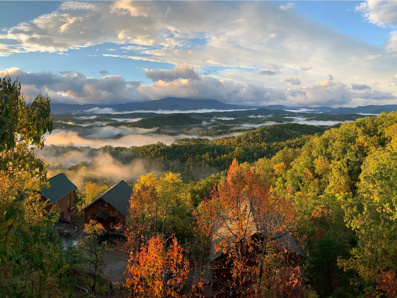 Autumn in Gatlinburg TN with fog and clouds over the hills during the best time to visit the Smoky Mountains