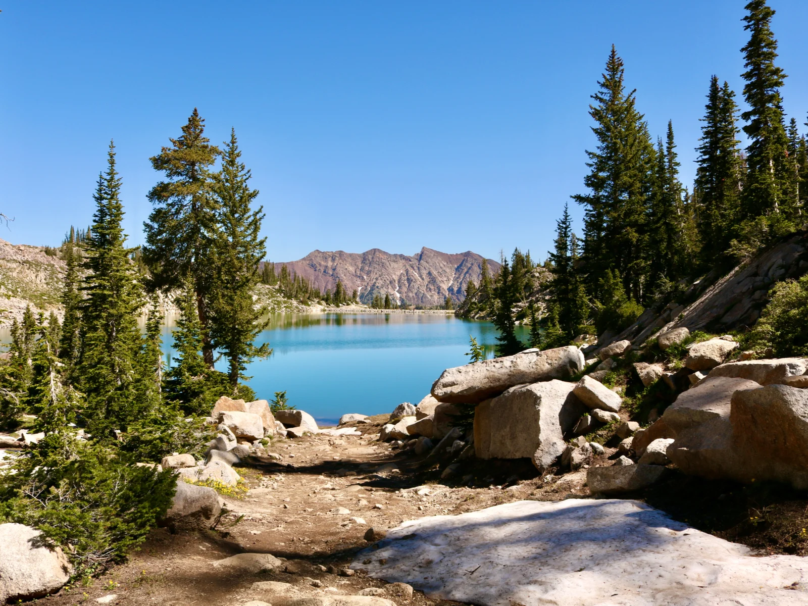 Gorgeous blue lake on a clear day with a mountain in the background with White Pine Lake in the middle during the best time to visit Utah