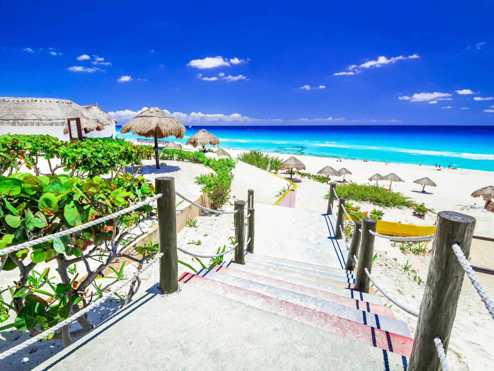View of stairs leading to a sandy beach during the best time to visit the best all-inclusive Cancun resorts for families