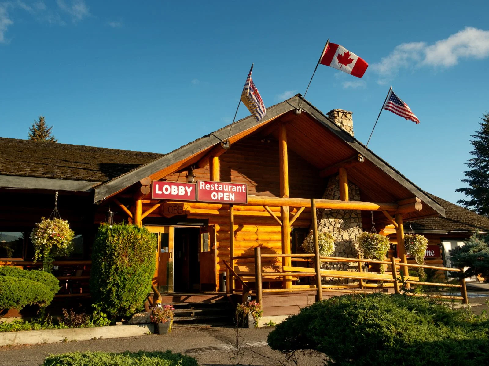 A log structure with a sign 'Lobby' and three flags on the roof of the Caribou Lodge Alaska, one of the best all-inclusive resorts in the U.S.
