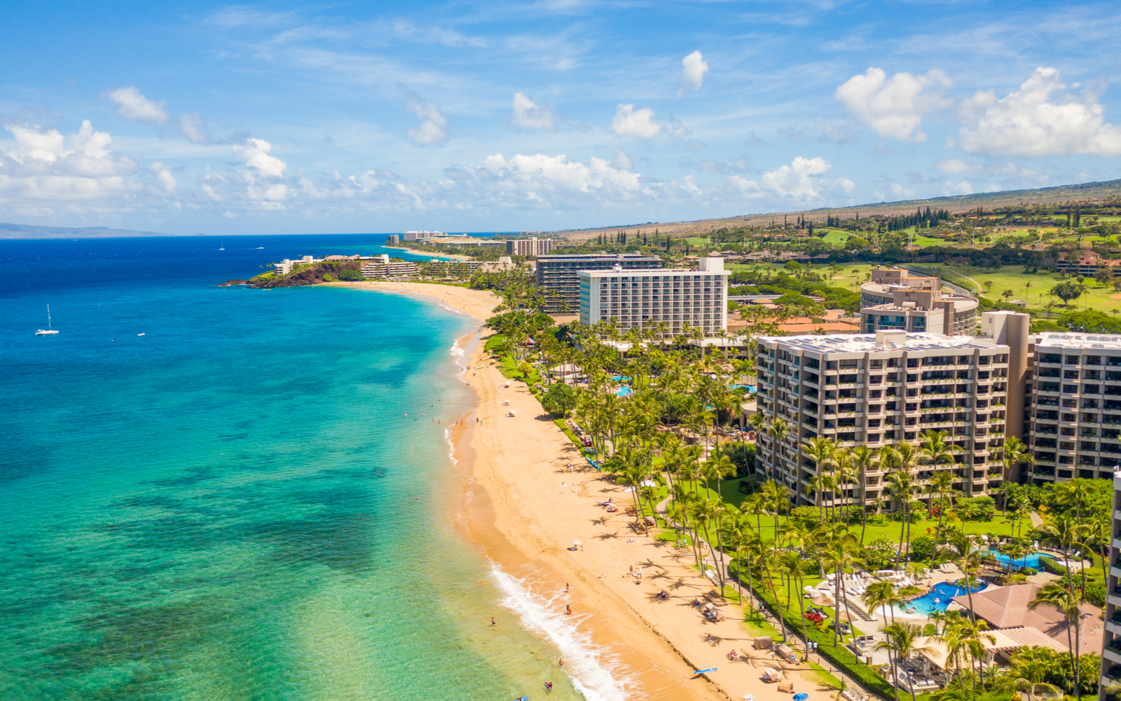 Featured image showing the teal water and sand with a view of some of the best hotels in Maui