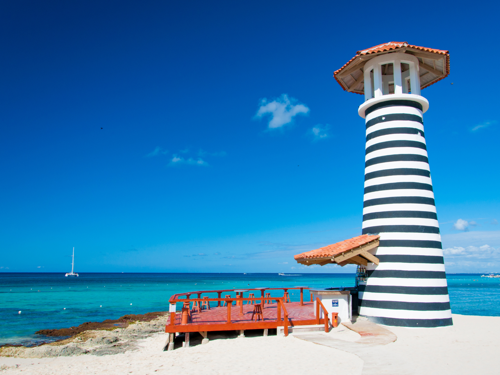 Ocean bar with a striped lighthouse pictured during the cheapest time to visit Punta Cana