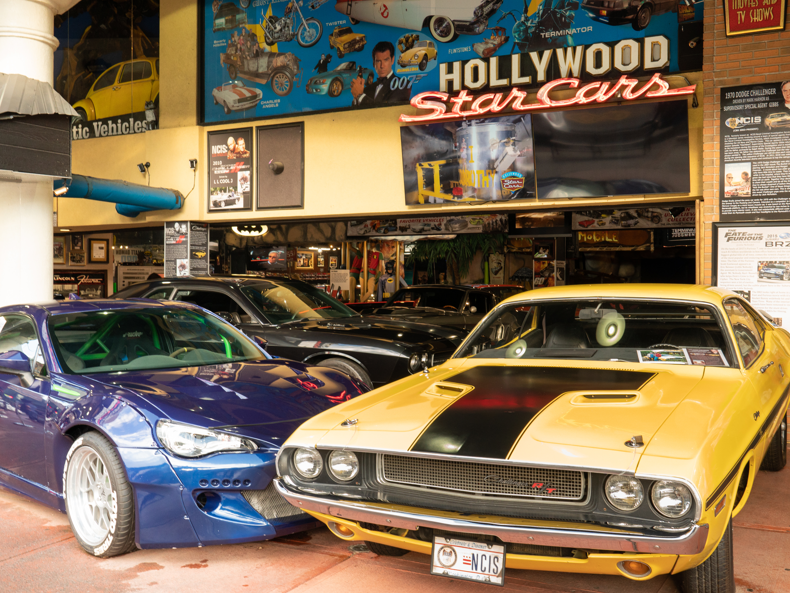 a vintage two-door yellow sedan, modern two-door sedan, and several other cars being exhibited at one of the best things to do in gatlinburg, tennessee, hollywood star cars museum
