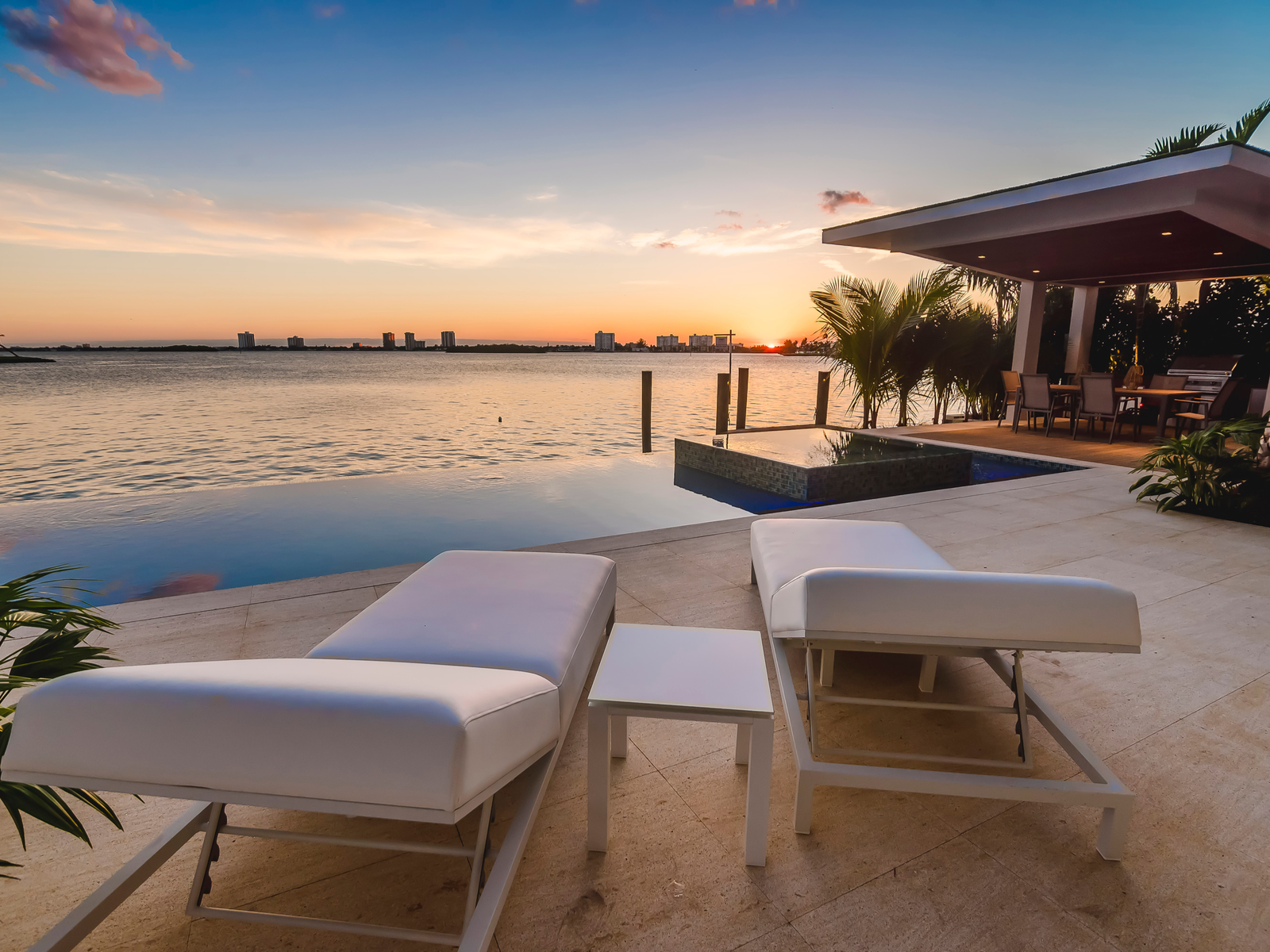 Beautiful sunset over the Miami bay viewed from empty sun loungers and infinity pool in one of the best all-inclusive resorts in the U.S.