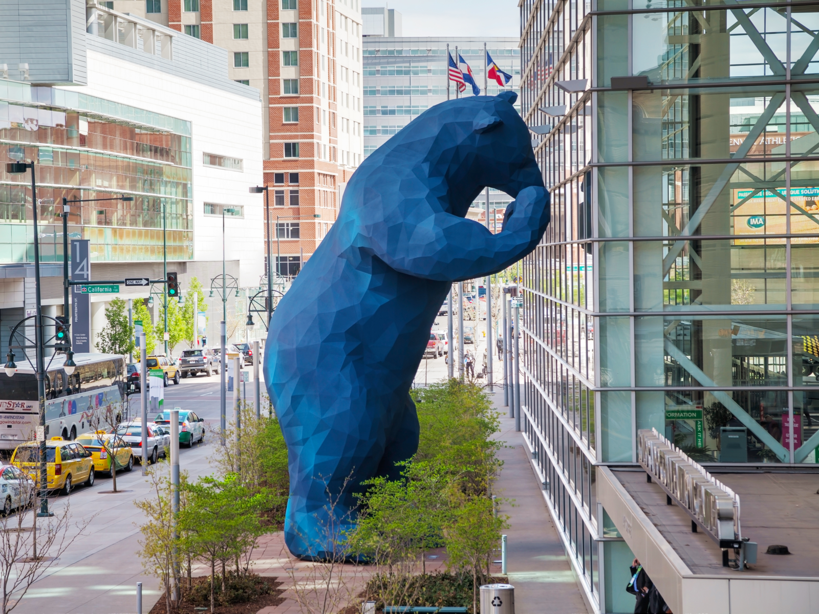 Giant blue bear standing against the event center glass looking in during the Winter, the worst time to visit Denver