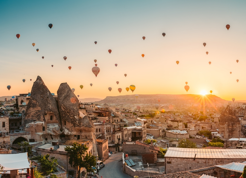 Many colorful balloons over fairy chimneys in Goreme, Cappadocia, Turkey