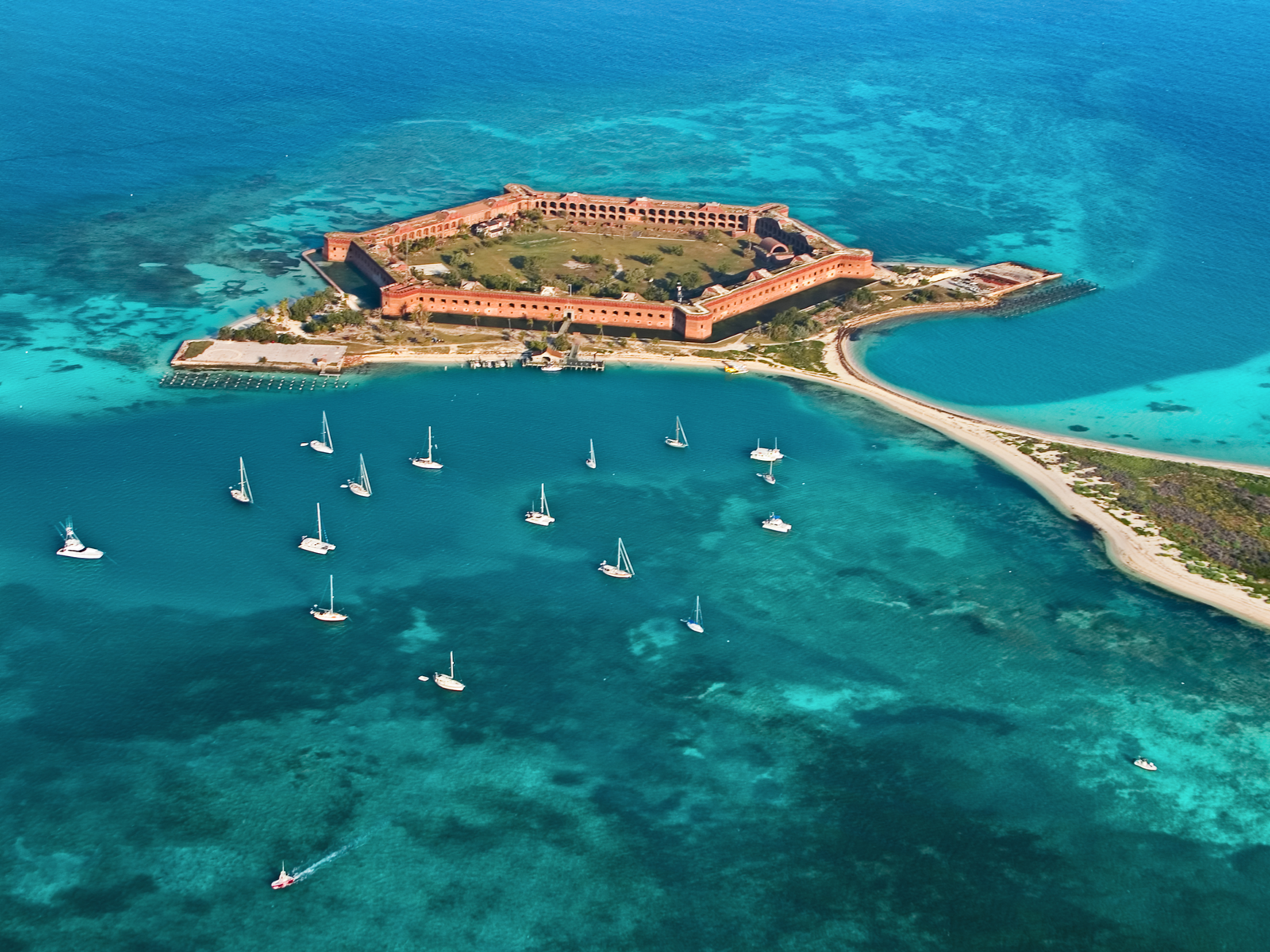 Aerial view of Fort Jefferson and many boats sailing by the clear waters of Dry Tortugas National Park, one of the best things to do in Key West