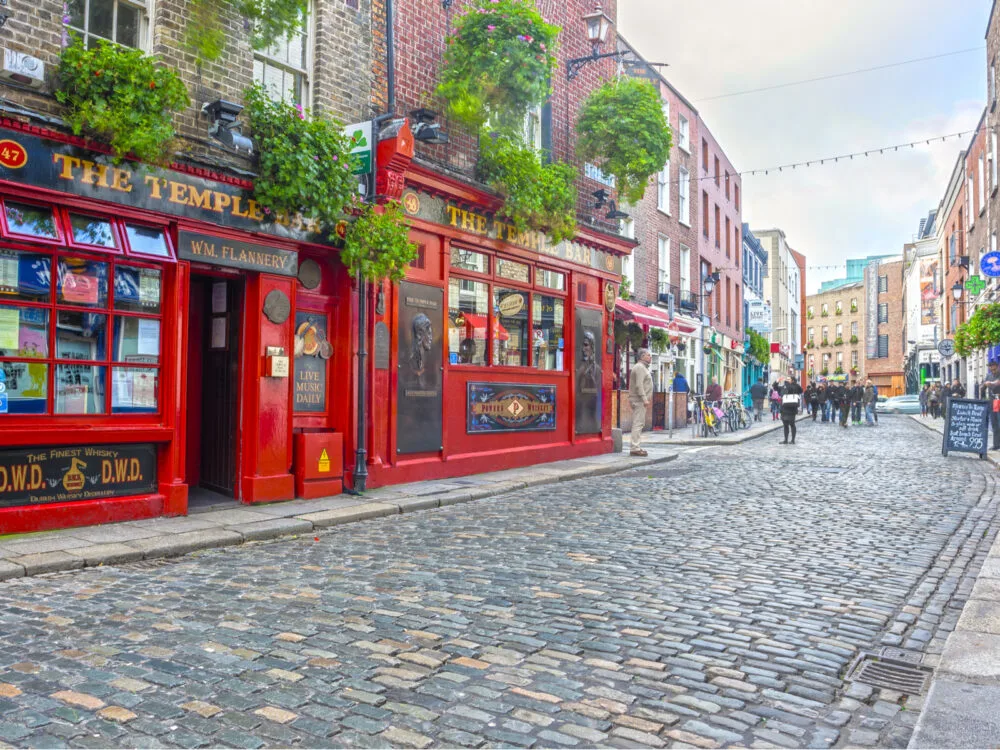 The Temple Bar in Dublin by the cobblestone street during the cheapest time to visit Ireland