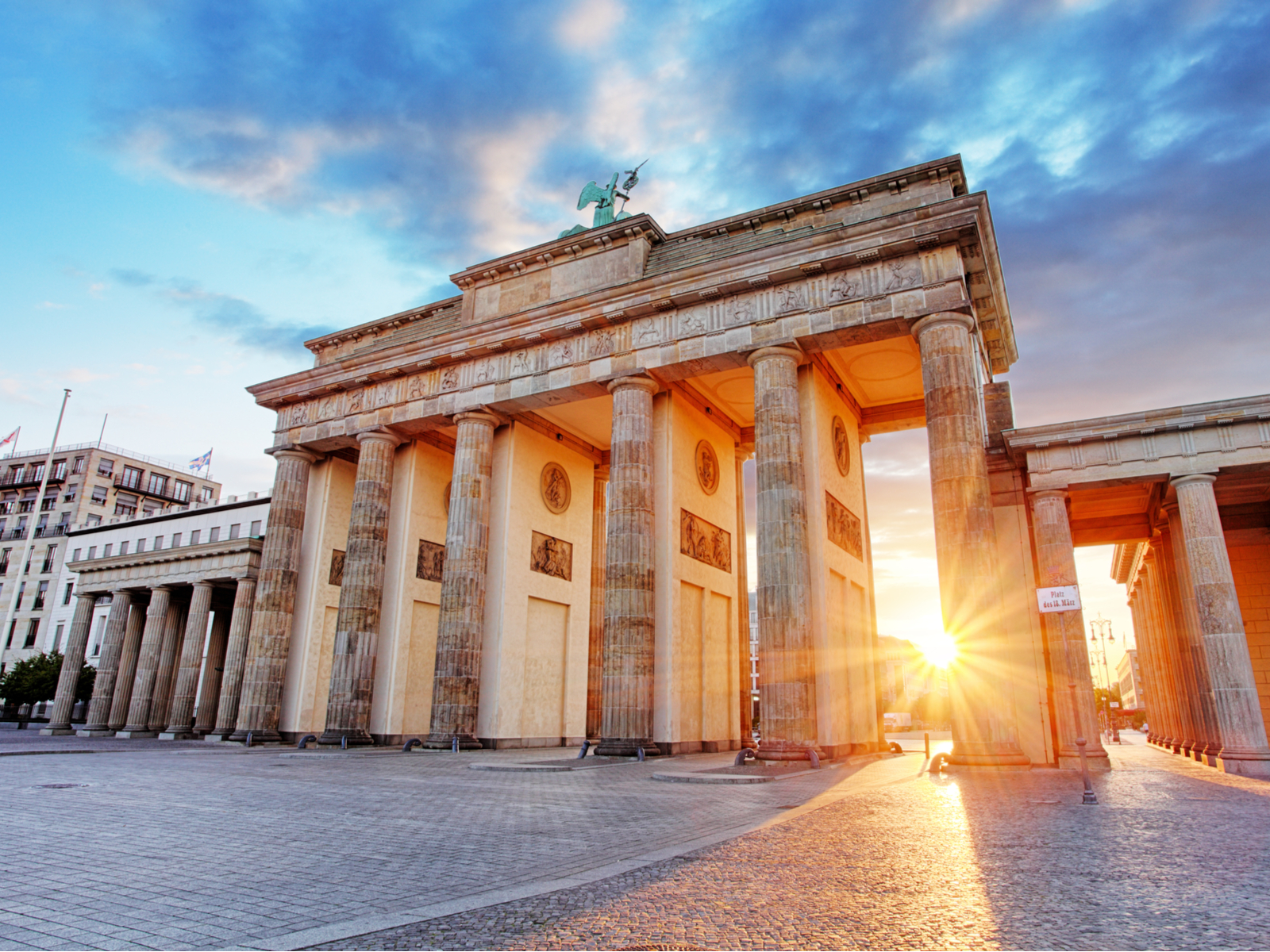 Brandenburg Gate with sun in the background peeking through the columns during the best time to visit Germany