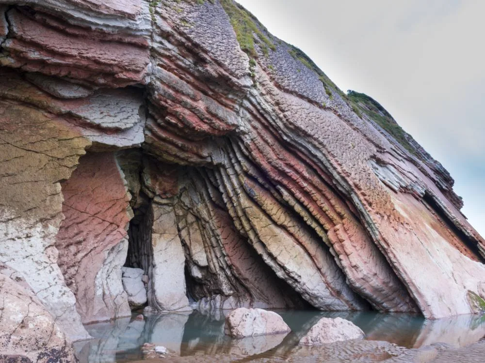 Large rock cavities formed overtime at a rocky coast of Itzurun Beach in Spain, one of the notable Game of Thrones filming locations you can visit