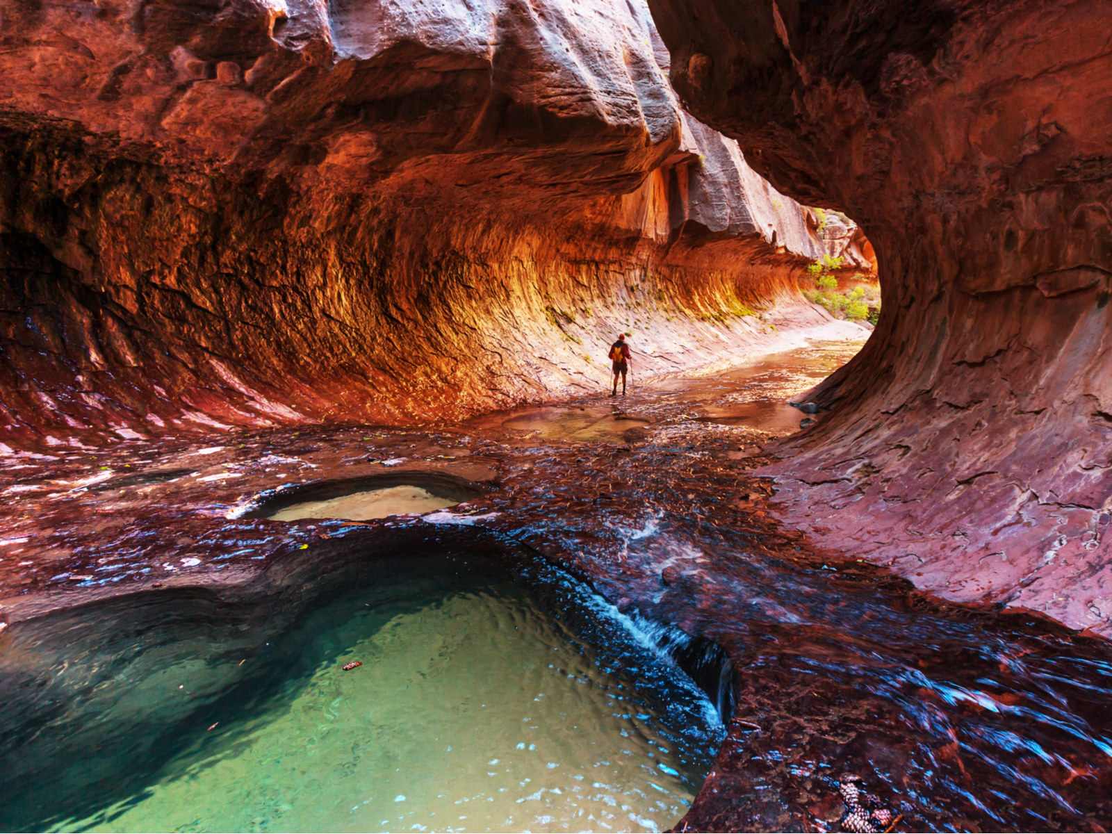 The Narrows in Zion National Park during the best time to visit featuring running water and multiple colors of rocks