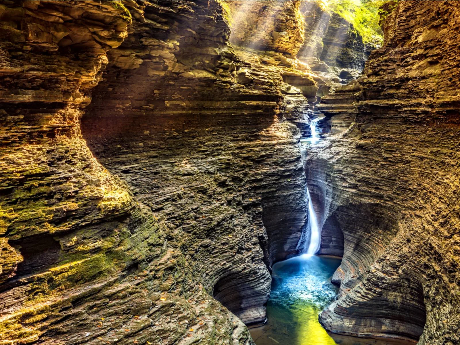 A waterfall canyon in Watkins Glen State Park with patches of moss covering rocks and clear waters, a piece on the most beautiful places in the US