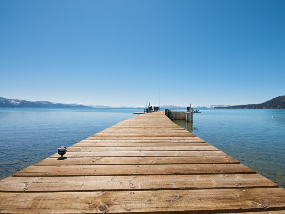 Low view of the long wooden pier above Lake Tahoe during the best time to visit, the Summer