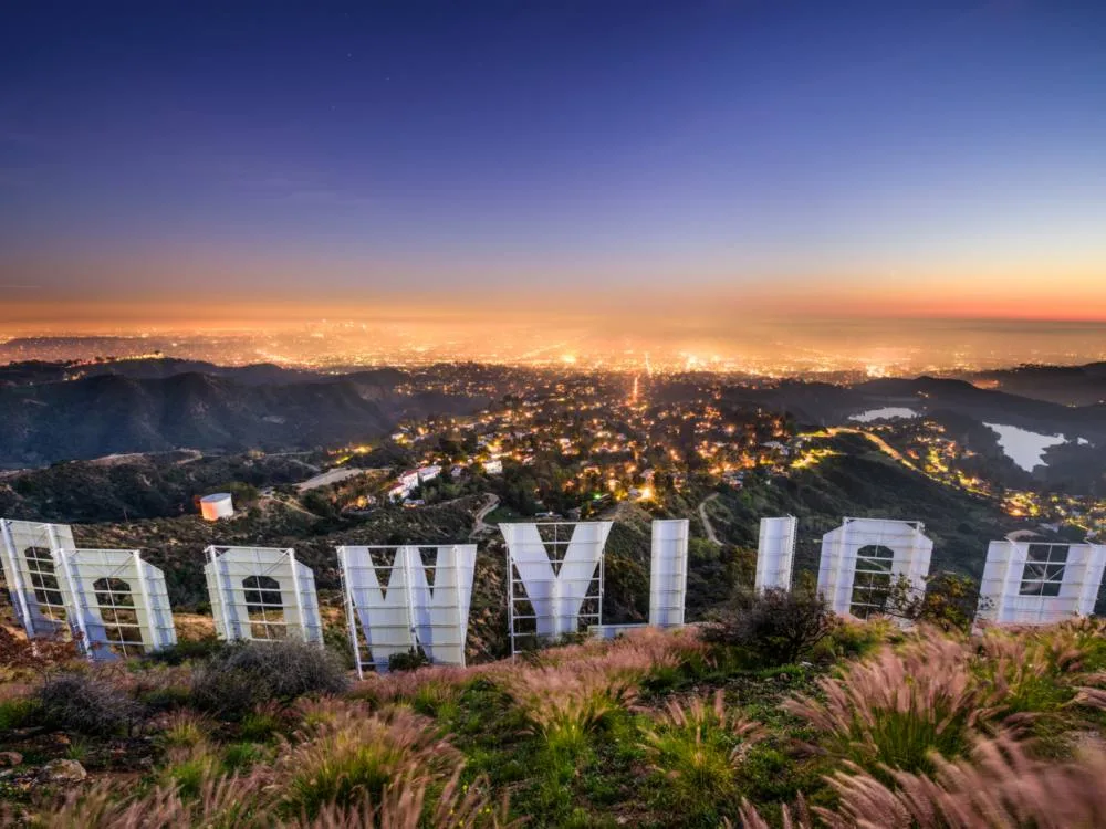 Up-close view of the iconic Hollywood sign, one of the best things to do in California, overlooking the city lights of Los Angeles