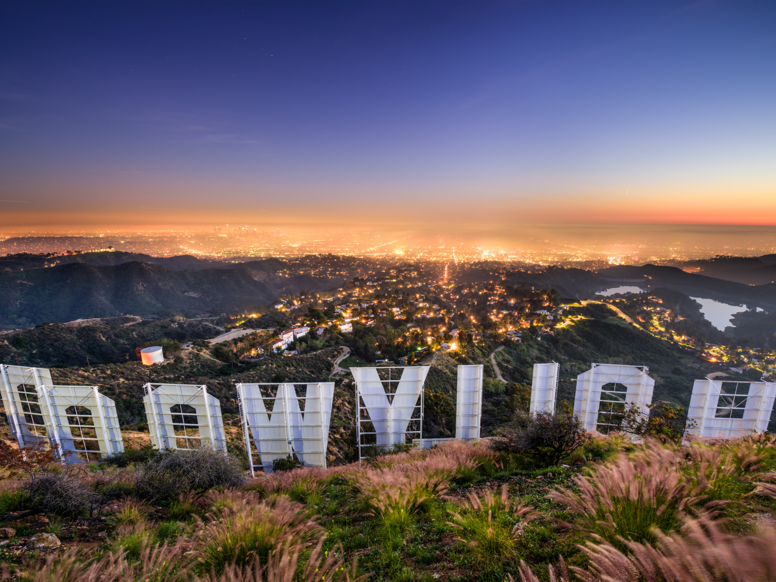 Up-close view of the iconic Hollywood sign, one of the best things to do in California, overlooking the city lights of Los Angeles