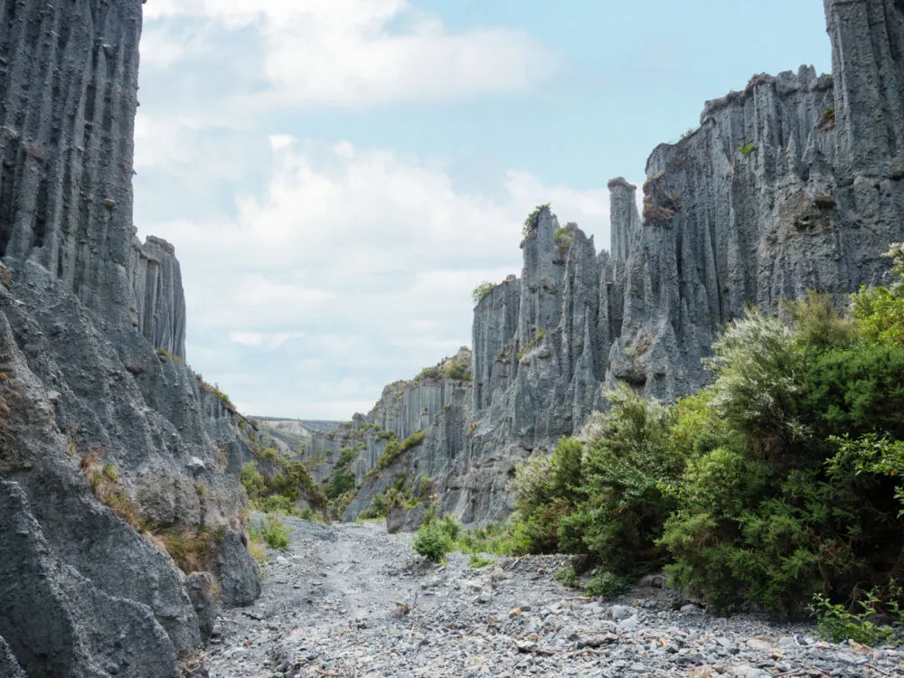 Sharp and spiky rock formation in one of the Lord of the Rings filming locations, Putangirua Pinnacles in the Aorangi Ranges during bright cloudy day