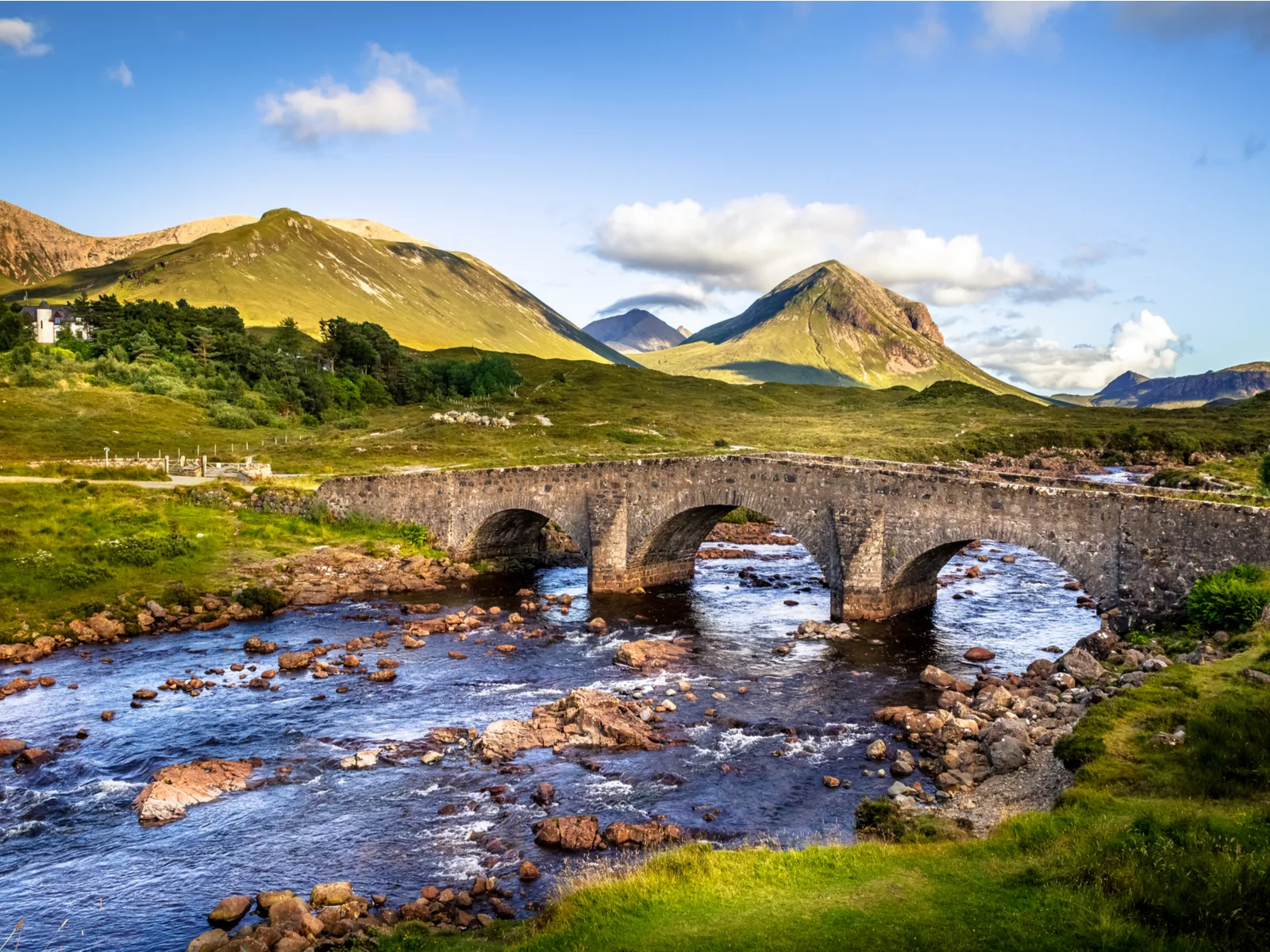 For a piece on the best time to visit Scotland, pictured is an old brick bridge across the river in Sligachan