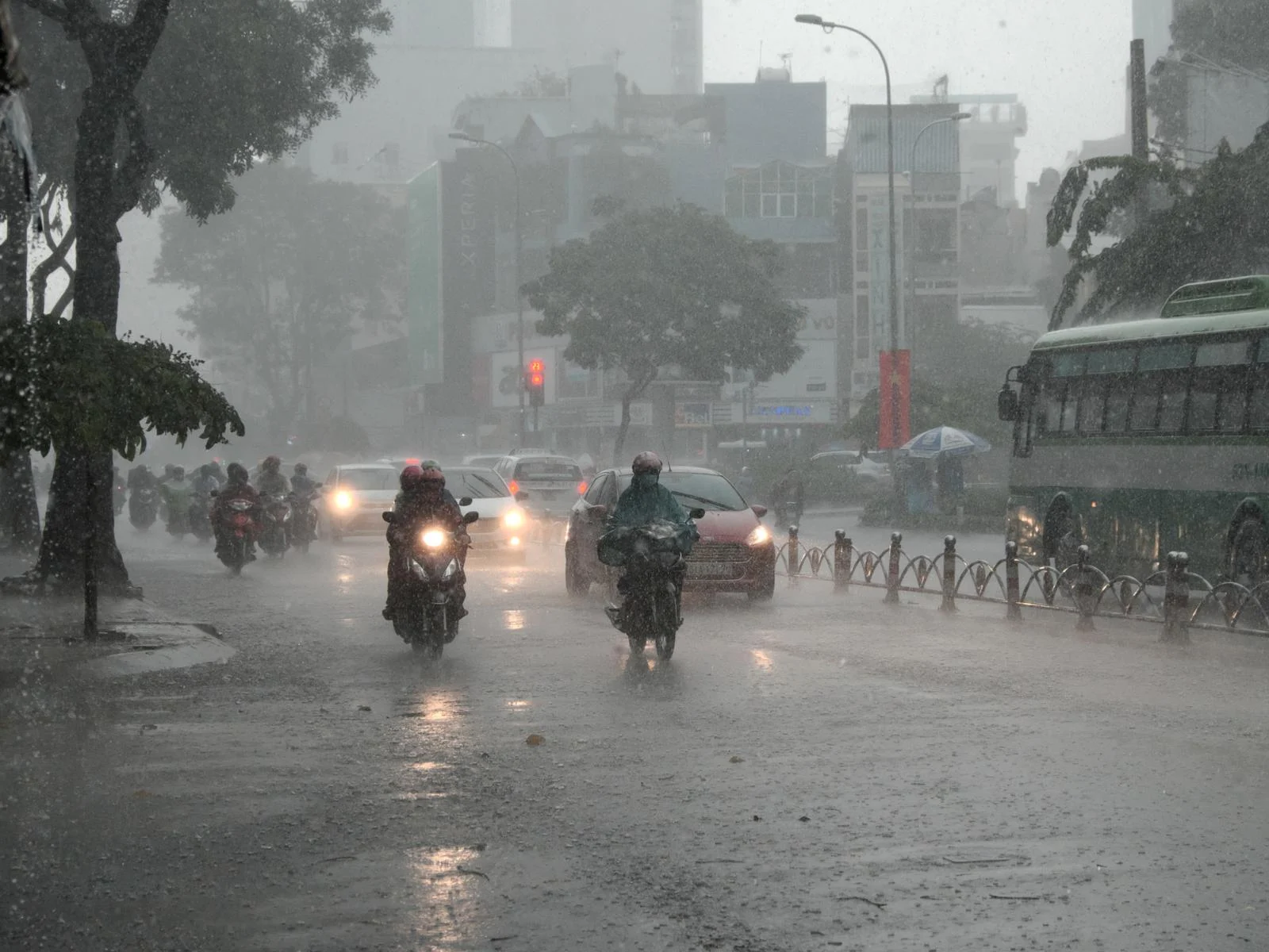 Ho Chi Minh during the worst time to visit Vietnam with rain pouring on people on motorcycles