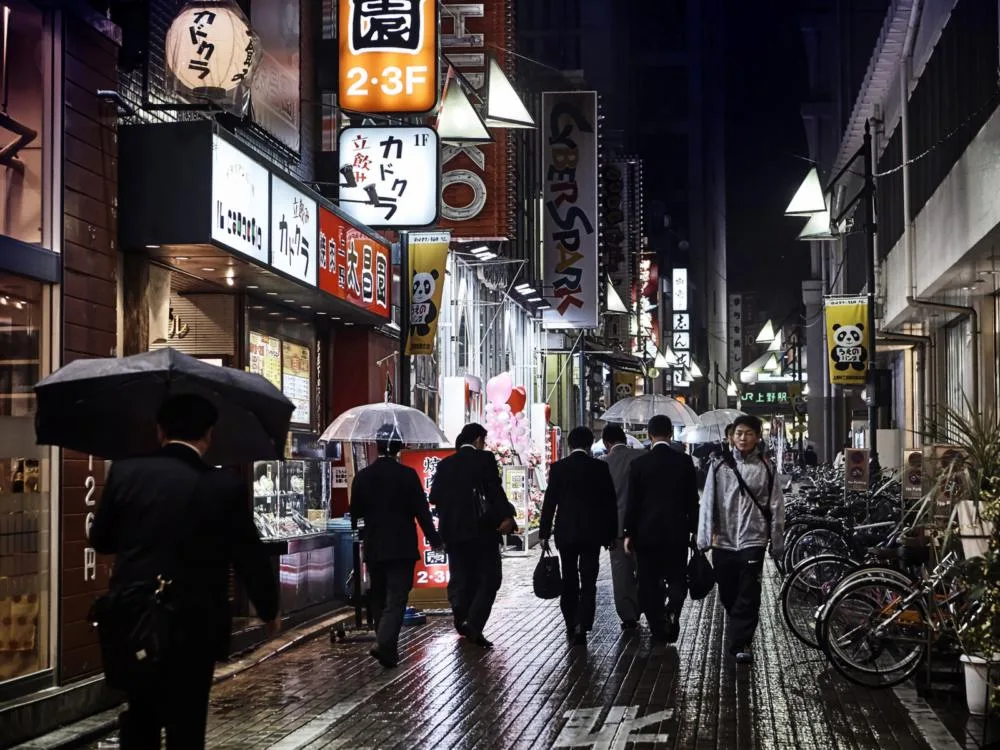People walking down the street in the rain during the worst time to visit Japan