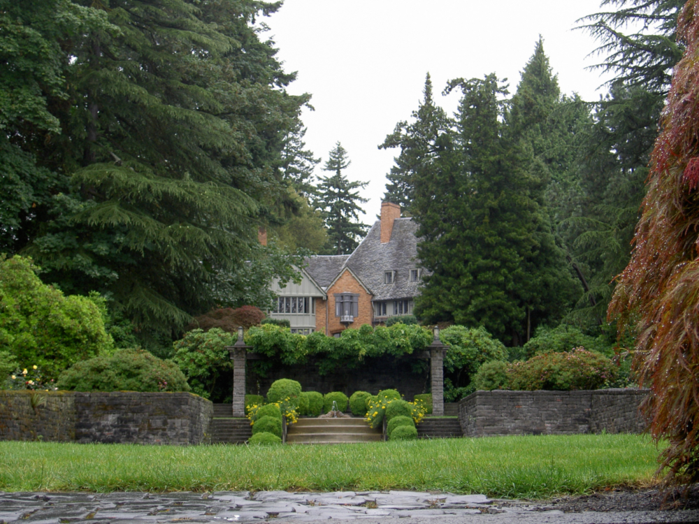 Historic campus buildings at Lewis and Clark College in Oregon, one of the most beautiful college campuses, obscured by blooming trees after a rain