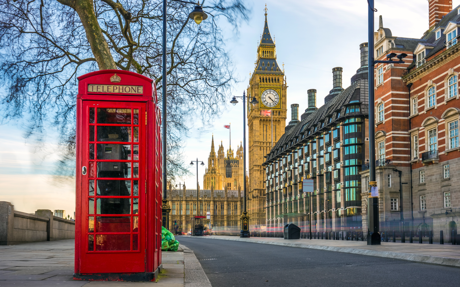 Iconic red telephone booth outside one of the historic buildings with Big Ben in the background during the best time to visit London